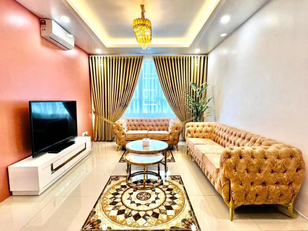 a living room with a couch and a television at Alaghapoo Service Apartment Near Drawbridge in Kuala Terengganu