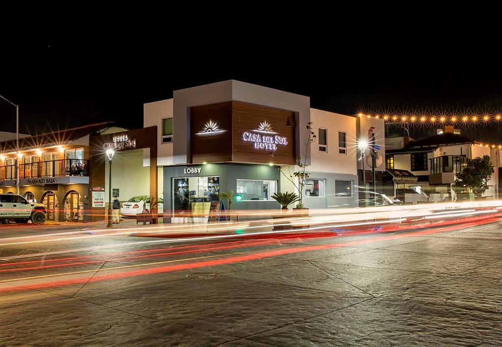 - un bâtiment situé dans une rue la nuit avec des panneaux lumineux dans l'établissement Hotel Casa del Sol, à Ensenada