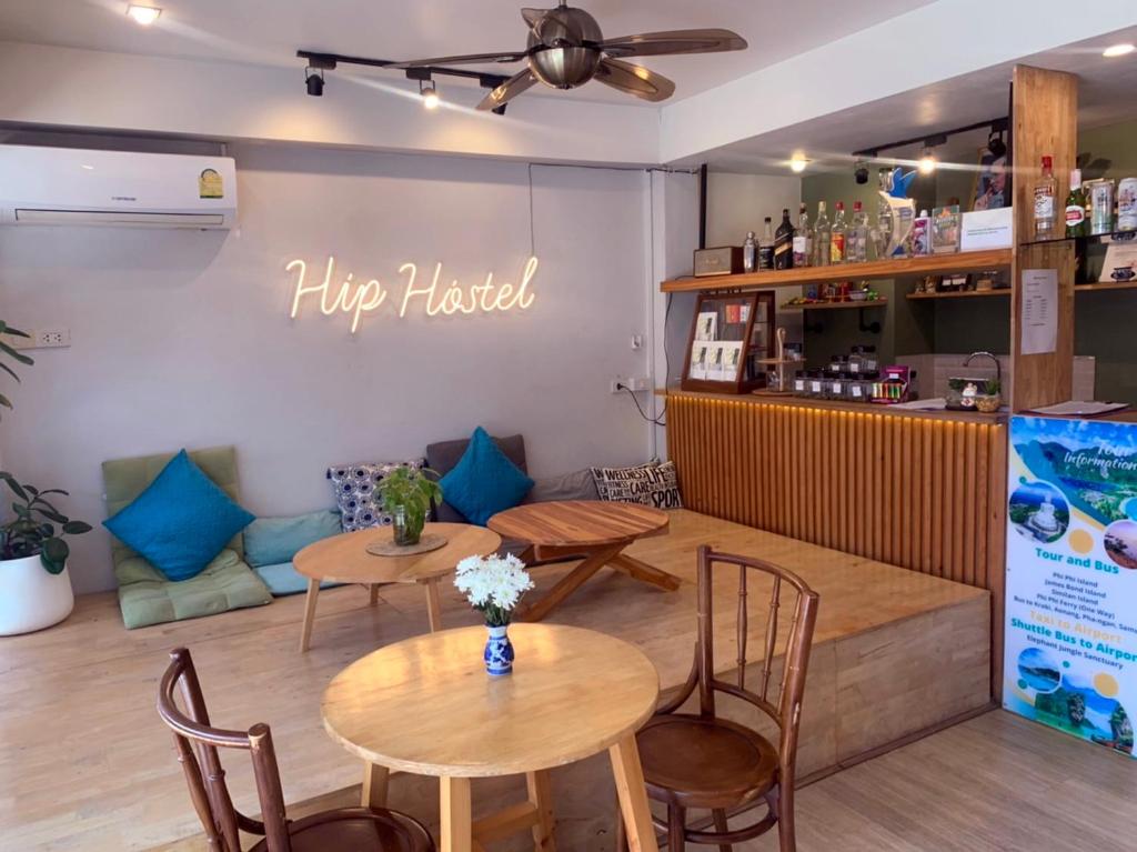 a coffee shop with two tables and a couch at Hip Hostel - SHA Plus in Patong Beach