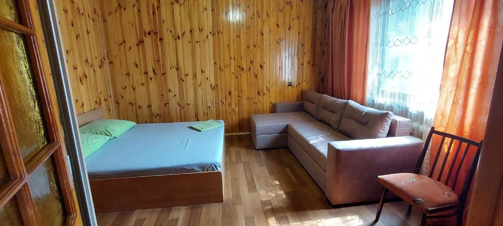 Habitación pequeña con sofá, cama y ventana en Holiday Home at Fedkovycha St. en Kiev