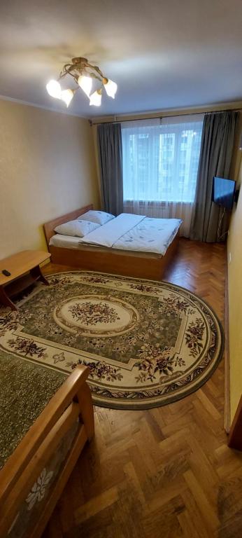 a bedroom with a bed and a large rug at Apartment on Patriarkha Mstyslava Skrypnyka Street in Kyiv