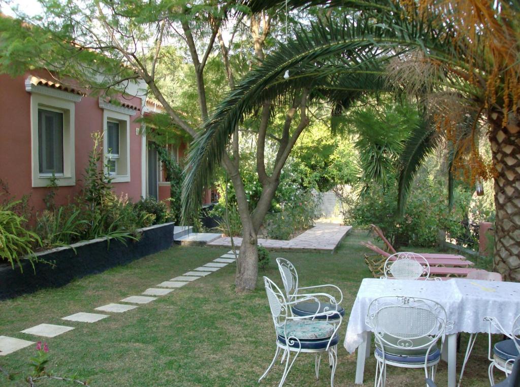 - une table et des chaises dans la cour d'une maison dans l'établissement Bozikis Apartments & Studios, à Paleokastritsa