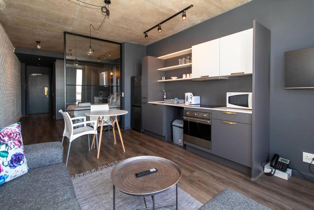 cocina y sala de estar con mesa y sillas en Gorgeous Studio 534 Wex 1, en Ciudad del Cabo