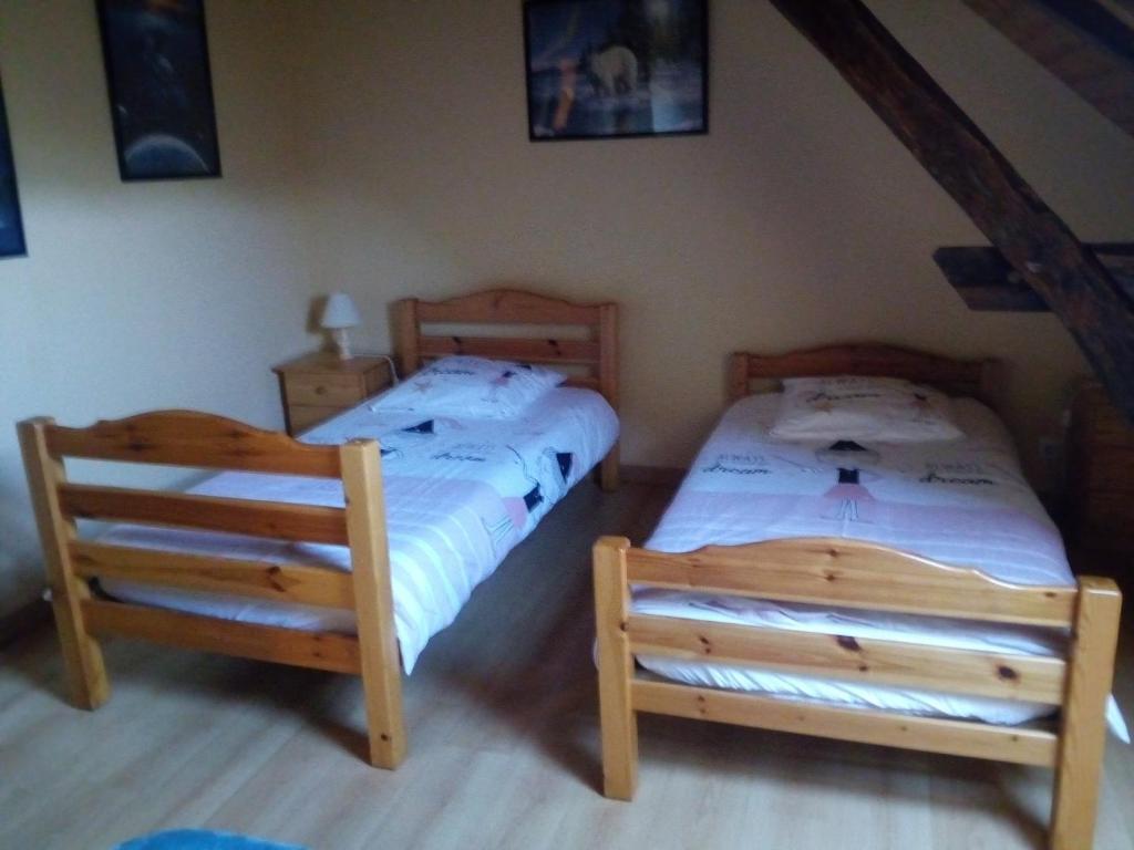 sypialnia z 2 łóżkami pojedynczymi i 2 krzesłami w obiekcie Les Grésilles w mieście Eyzerac