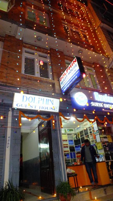 een man voor een winkel met een bord bij Hotel Dolphin in Kathmandu