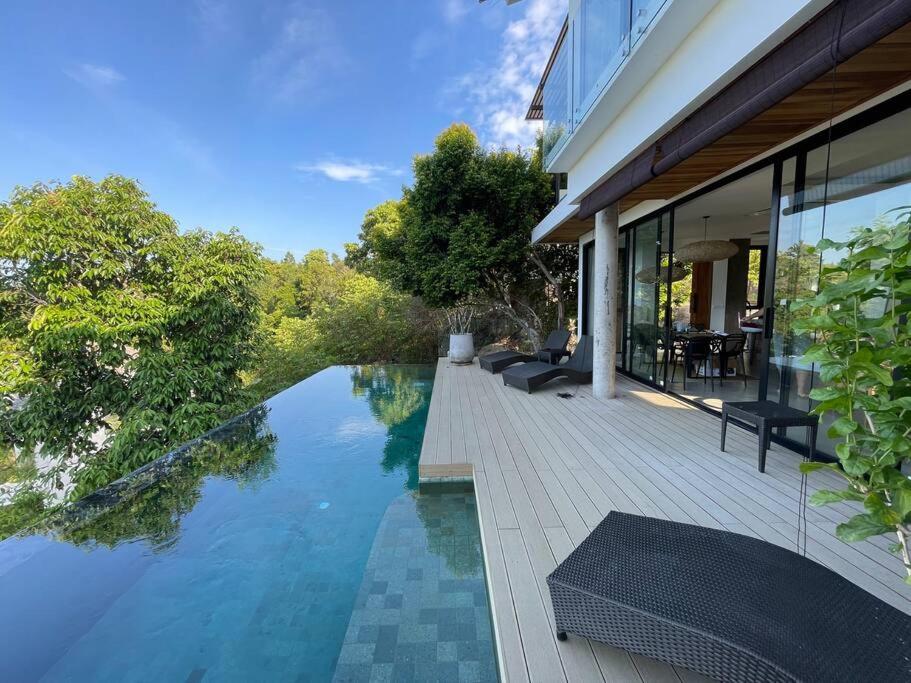 een huis met een zwembad naast een huis bij Villa Nour - 3 BR sea view pool villa in Srithanu in Srithanu