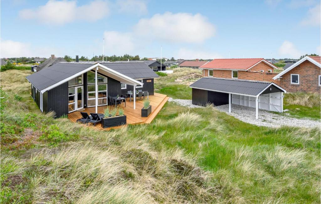 a house on the beach with a deck at Lovely Home In Ringkbing With Wifi in Søndervig
