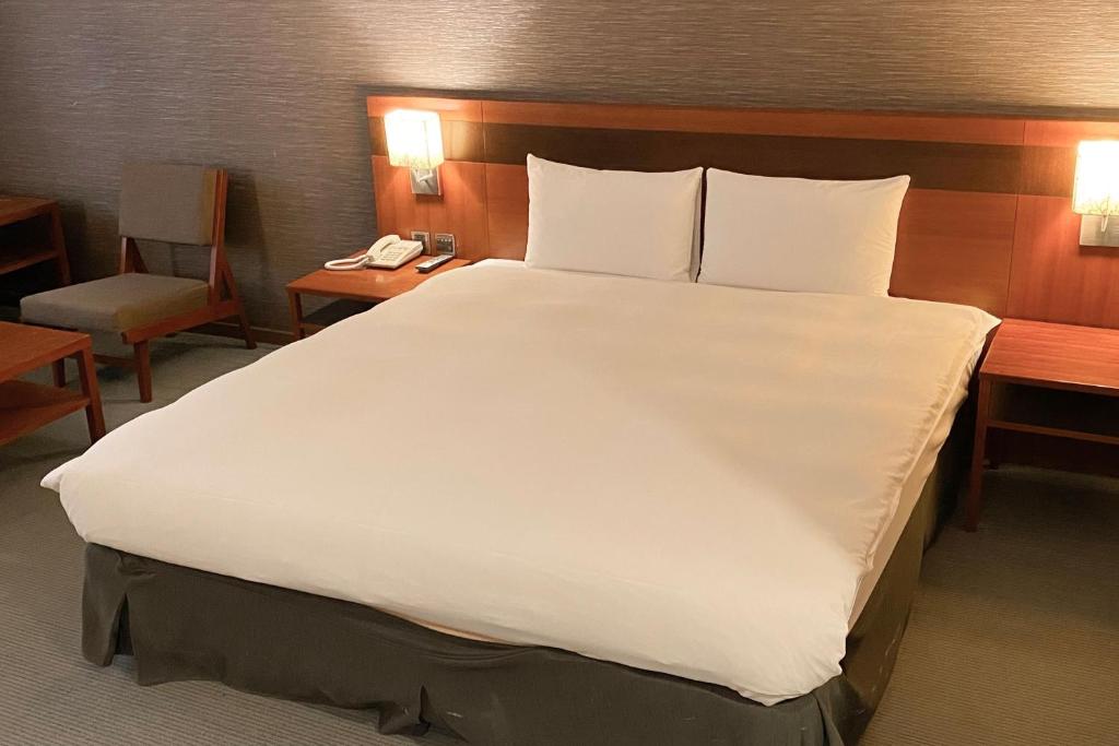 Postel nebo postele na pokoji v ubytování Guide Hotel Hsinchu Zhongyang