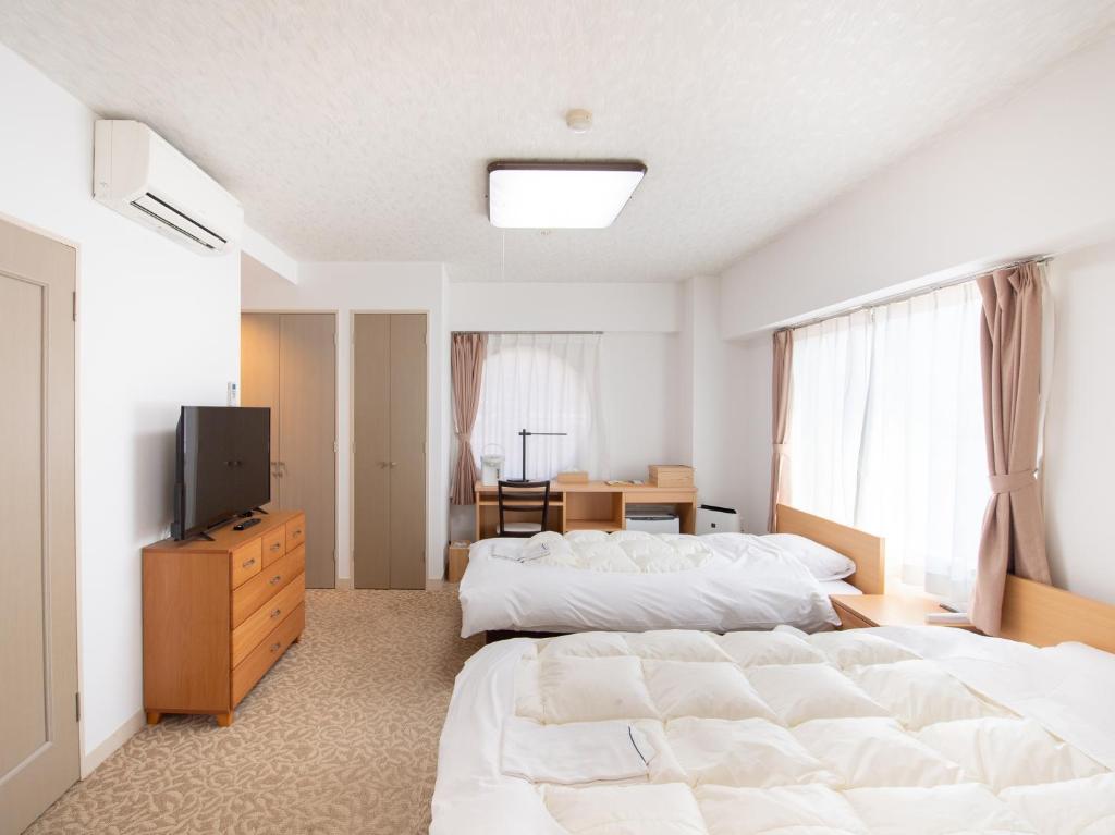 Postel nebo postele na pokoji v ubytování Chateraise Lodge Kasugai