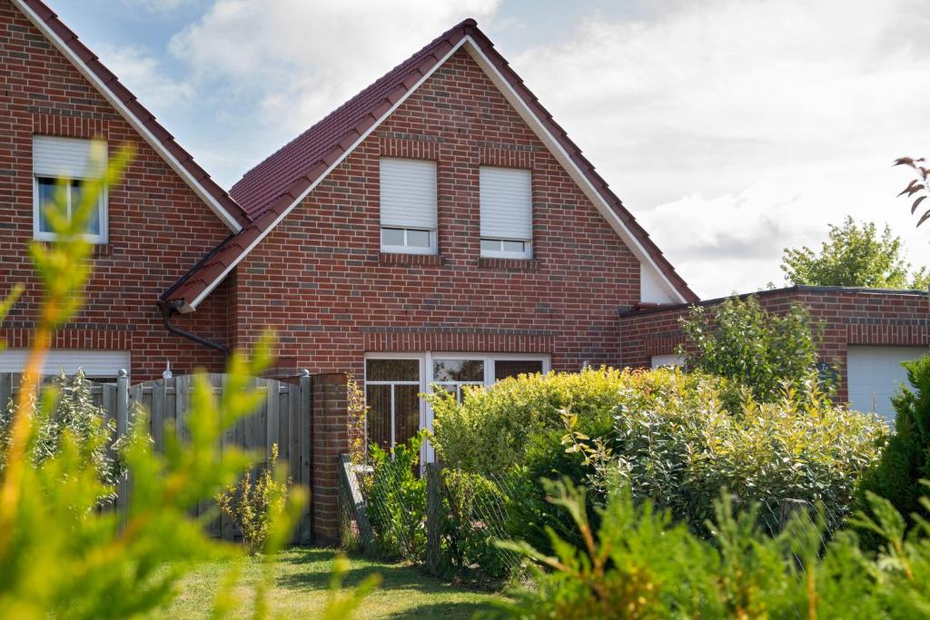 a red brick house with white windows at Ferienhaus Sabine Norddeich in Norddeich