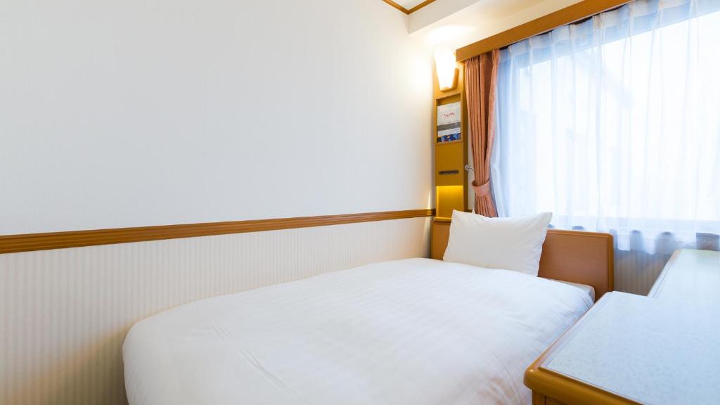 Postel nebo postele na pokoji v ubytování Toyoko Inn Yokohama Sakuragicho