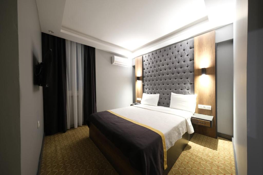 a hotel room with a bed and a wall at Eniza Hotel in Mersin