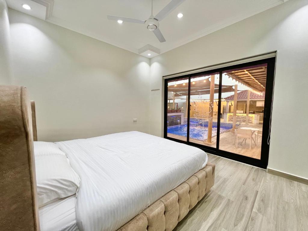 AlDana Resort & Hotels في بركاء: غرفة نوم بسرير كبير ونافذة كبيرة