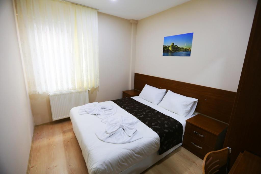 a bedroom with a bed with white sheets and a window at Istanbul Family Apartment in Istanbul