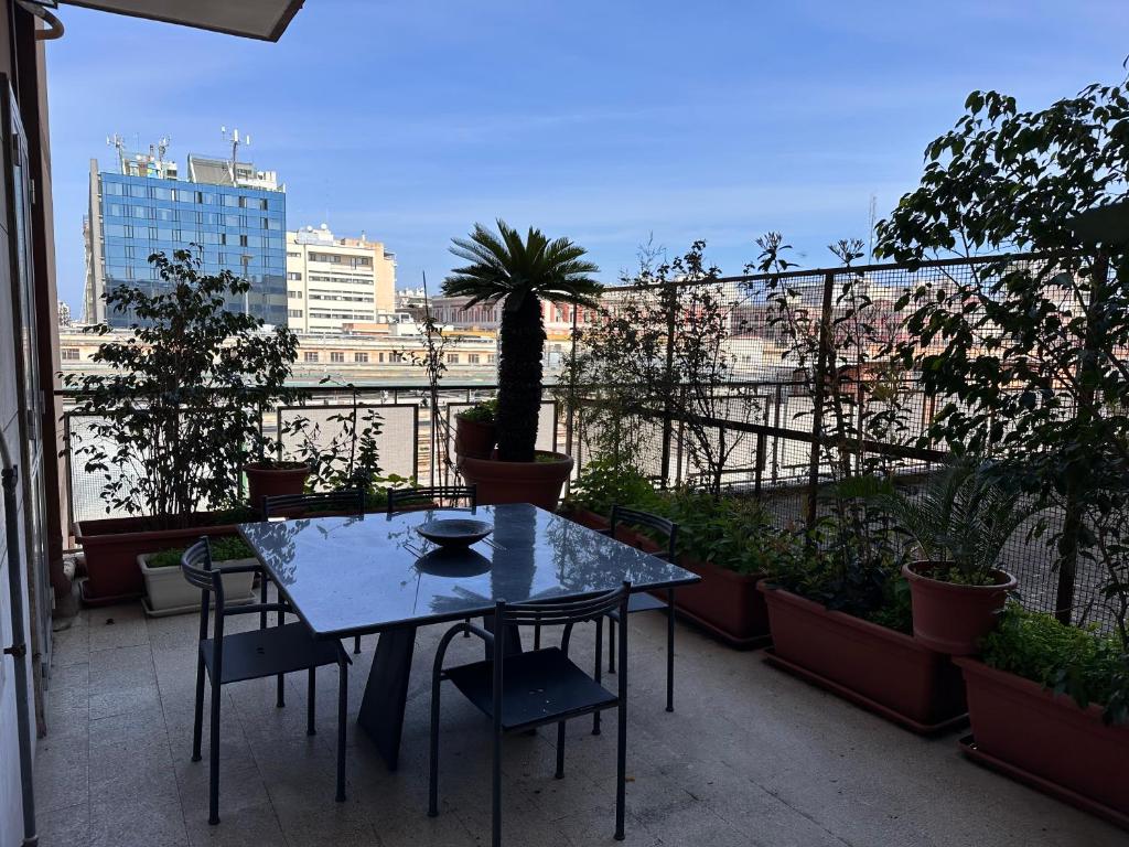 a table and chairs on a balcony with plants at house green station in Bari