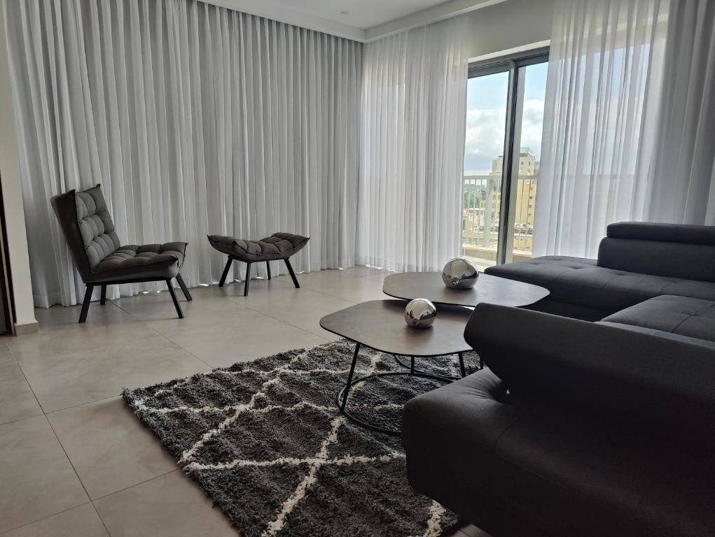 ein Wohnzimmer mit einem Sofa und einem Tisch in der Unterkunft Savyon View Tower - 2BR apartment in Jerusalem