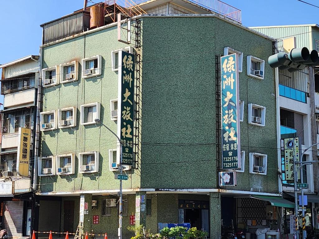 a green building with writing on the side of it at Lu Zhou Hotel in Pingtung City