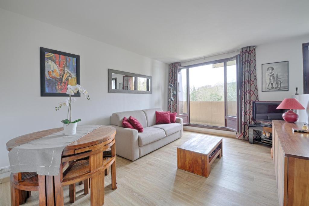 una sala de estar con un sofá y una mesa en Swingcat - Charmant appt pour 2, en Athis-Mons