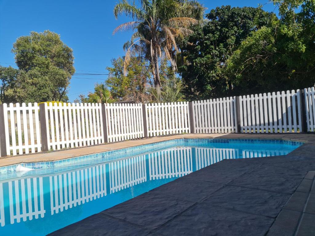 a white fence next to a swimming pool at Cobra Self-Catering Guesthouse in Citrusdal