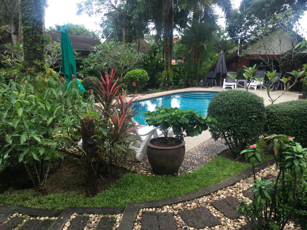 una piscina en un jardín con plantas en Sunflowerbungalow, en Khao Lak