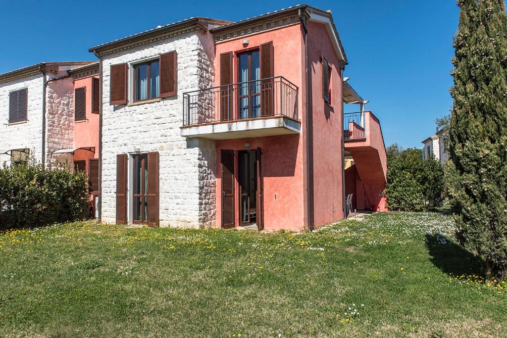 a large brick house with a balcony on a yard at M347 - Marcelli, comodo trilocale nuovo con piscina e giardino in Santa Maria a Potenza