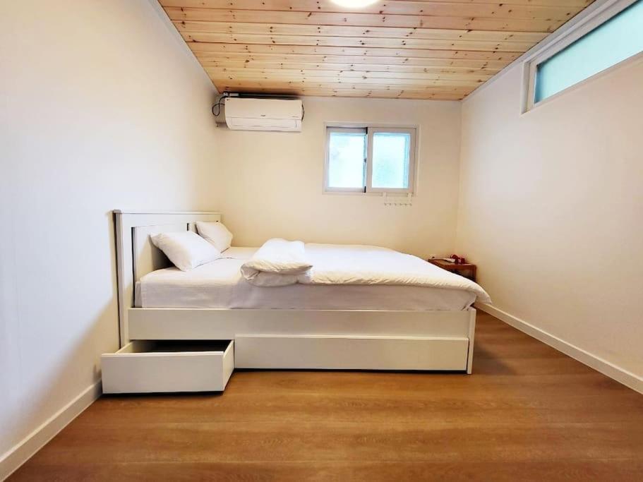 een slaapkamer met een bed in de hoek van een kamer bij Sam House 2 Seochon in Seoul