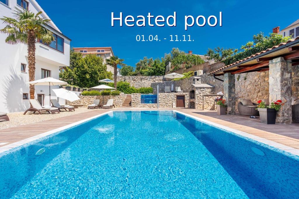 a swimming pool in a villa with a heated pool at Apartments Petra Krk in Krk