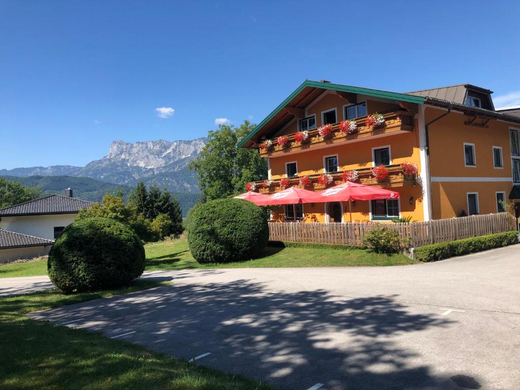 a building with red umbrellas in front of it at Pension David in Puch bei Hallein