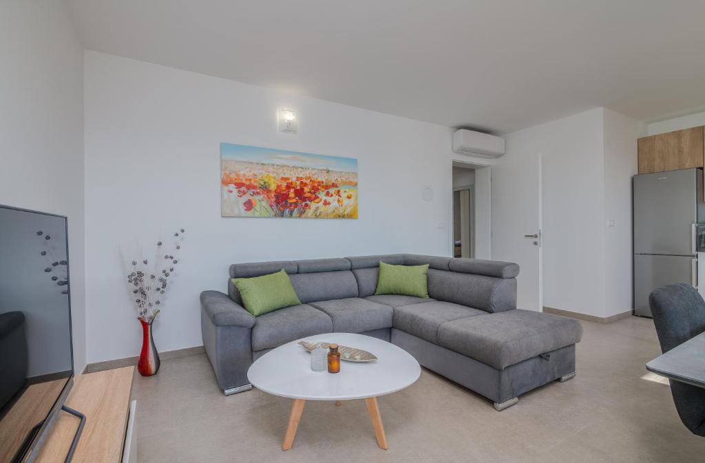 ein Wohnzimmer mit einem Sofa und einem Tisch in der Unterkunft Apartments Sunrise Krk in Krk