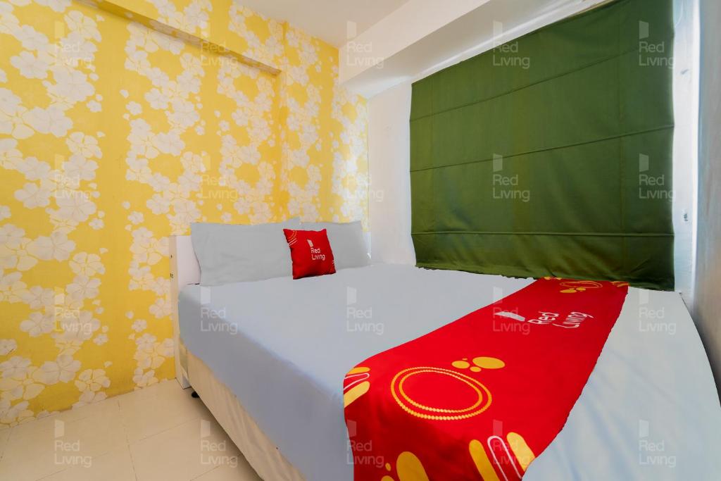 sypialnia z białym łóżkiem i czerwonym kocem w obiekcie RedLiving Apartemen Bassura City - Gracefull Rooms Tower Dahlia w Dżakarcie
