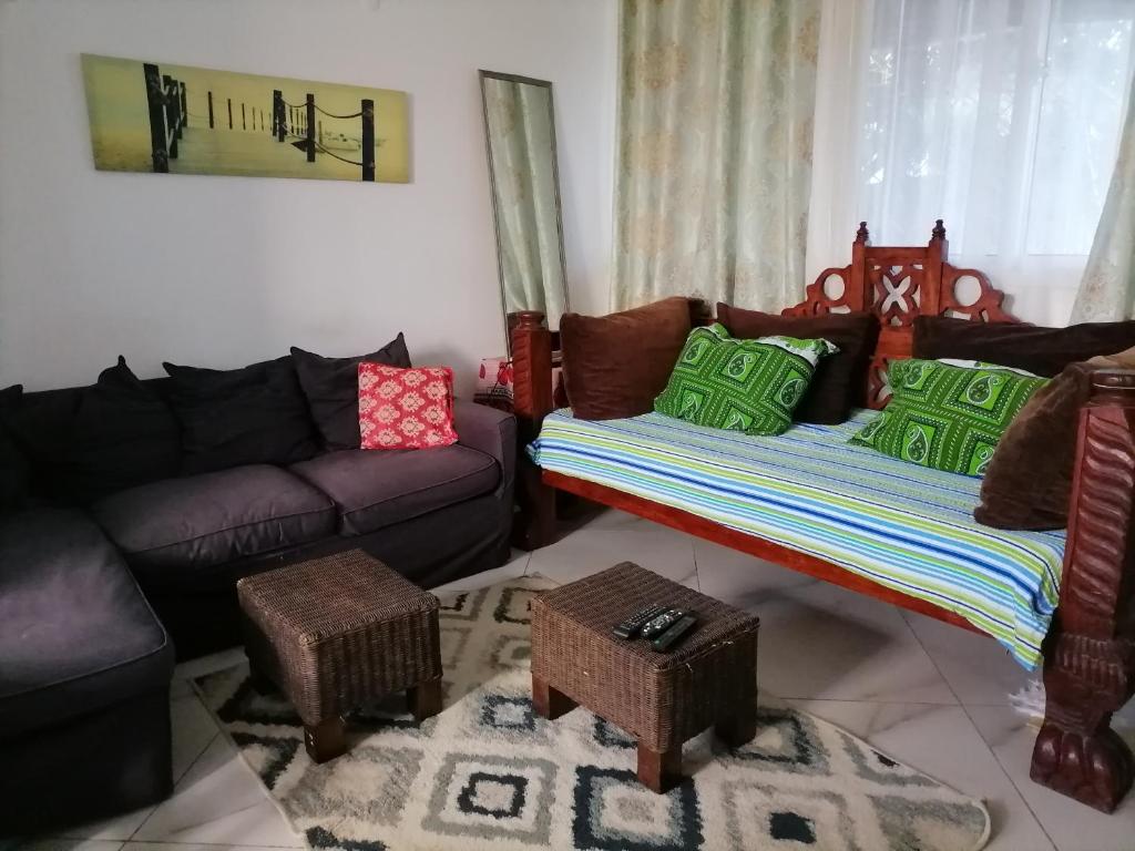 een woonkamer met een bank, een bank en een tafel bij Serene 2 bedroom homestay 15mindrive to the beach in Mombasa