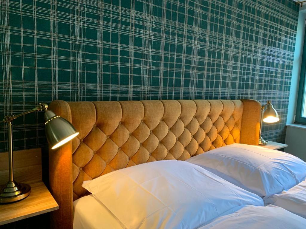 Bett mit einem getufteten Kopfteil in einem Schlafzimmer in der Unterkunft Der grüne Fürst Ferienwohnung Appartement 1 in Bad Muskau