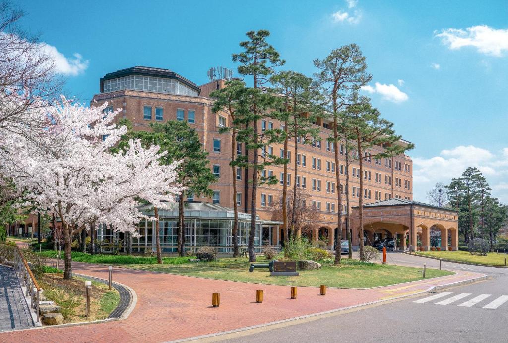 a large brick building with trees in front of it at Mayfield Hotel Seoul in Seoul