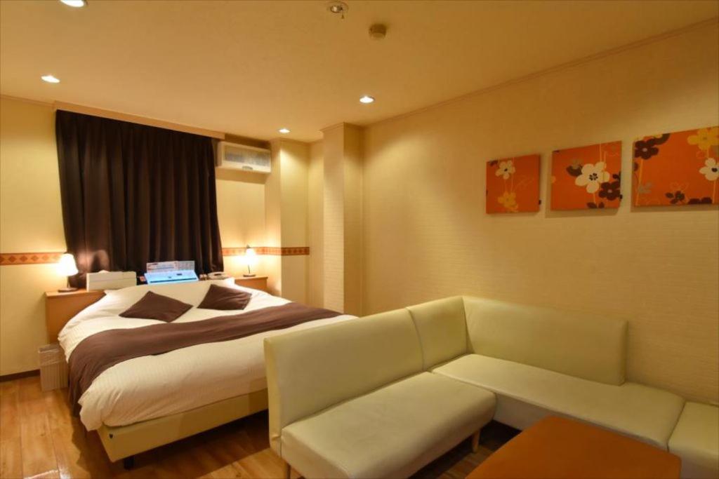a hotel room with a bed and a couch at HOTEL TWO HEART - Adult Only in Fukushima