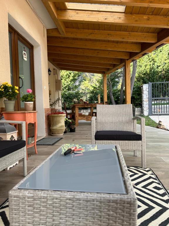 un patio con mesa y sillas en un porche en Domus Corinnae en Sulmona
