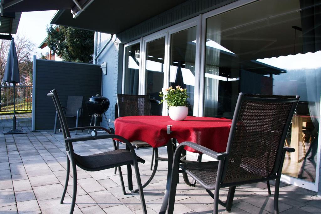 a patio table with a red table cloth and chairs at Ferienwohnung Ricke in Krombach
