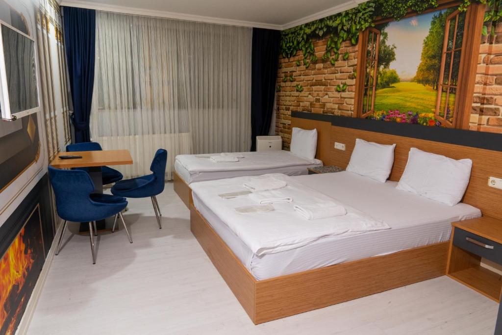 a hotel room with two beds and a television at Heraldic Room Hotel in Esenyurt