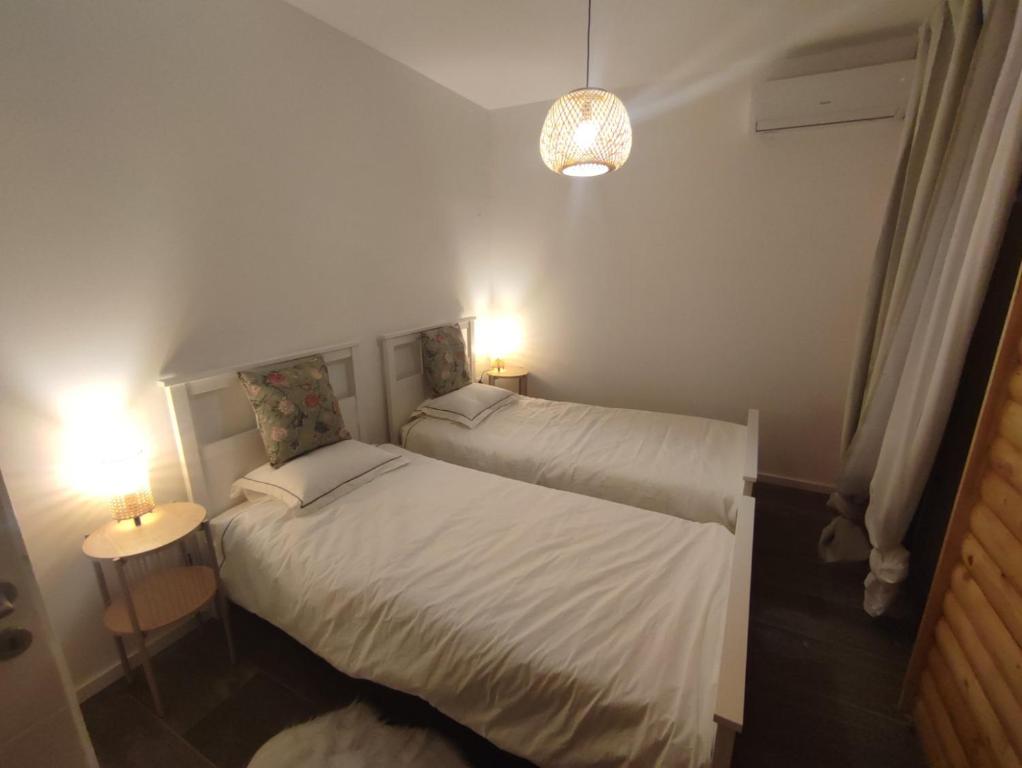 two beds in a small room with two lamps at Laganini Country in Samobor