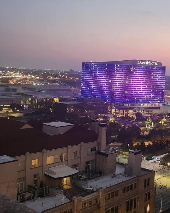 un bâtiment éclairé avec des lumières violettes dans une ville dans l'établissement Awesome! Apartment in Downtown Dallas, à Dallas