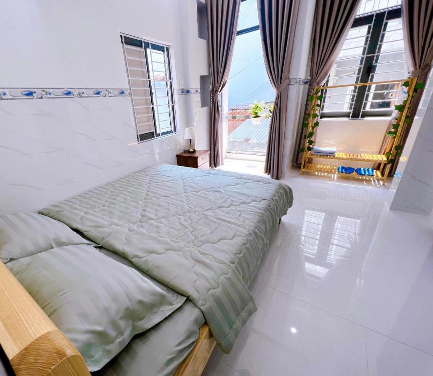 a bedroom with a bed and a large window at Suri's Homestay in Quy Nhon