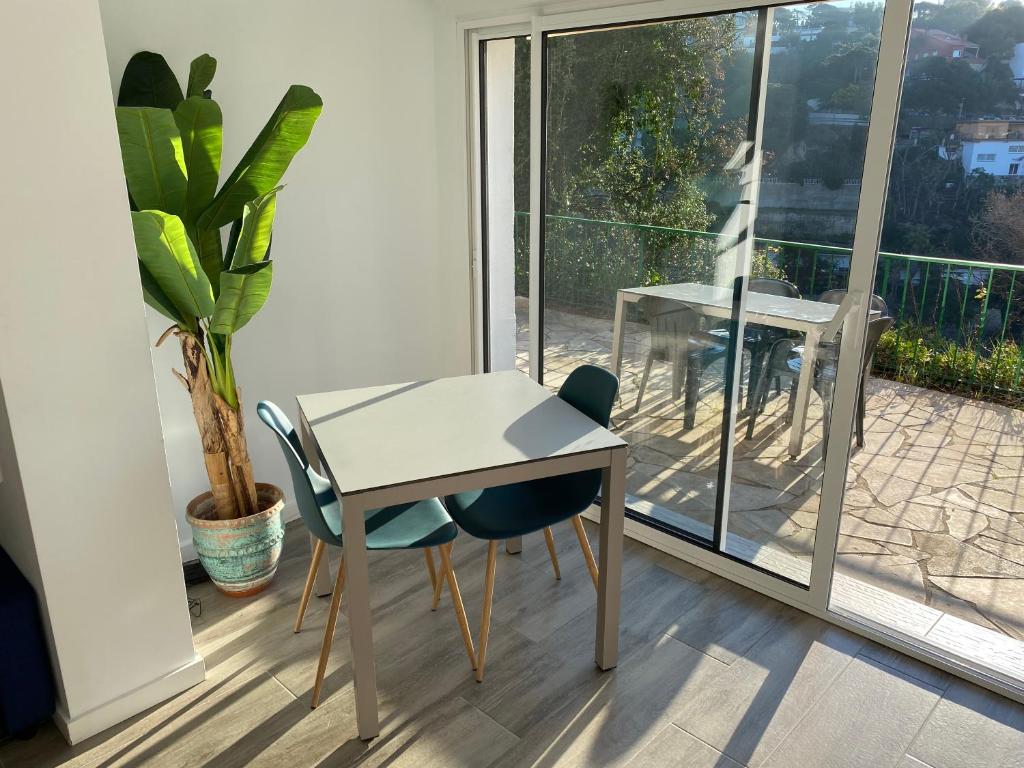 a table and chairs in a room with a balcony at Canyelles BBQ Apartment in Lloret de Mar