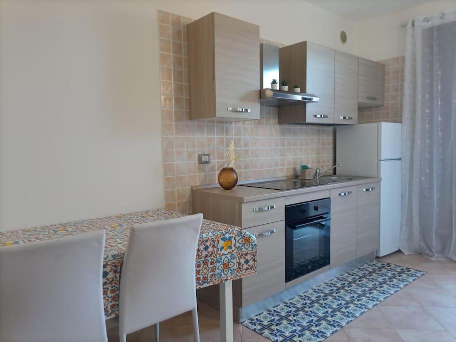 uma cozinha com uma mesa e um fogão forno superior em Chilù em Cagliari