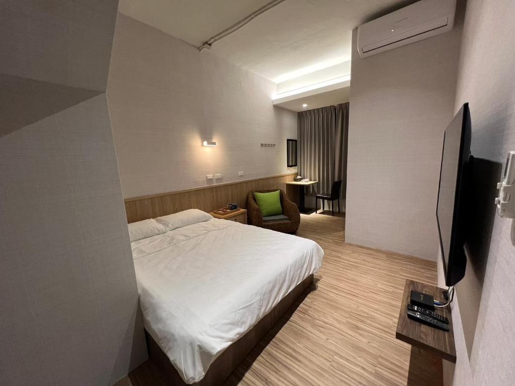 a hotel room with a bed and a chair at Five Rabbits in Chaozhou