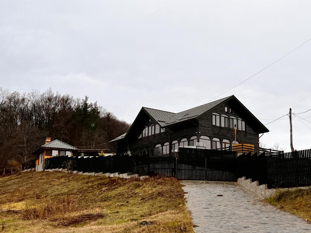 ein schwarzes und weißes Haus mit einem schwarzen Zaun in der Unterkunft Pensiunea Roxana in Buzău