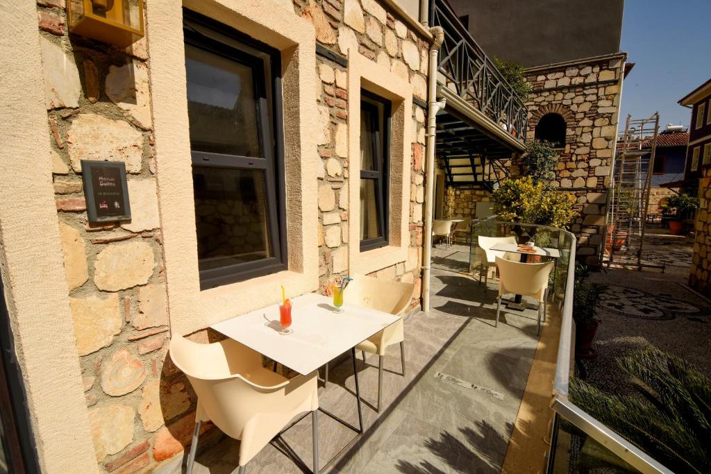een patio met een tafel en stoelen in een gebouw bij Lovely Garden Flat with Patio near Hadrian's Gate in Antalya
