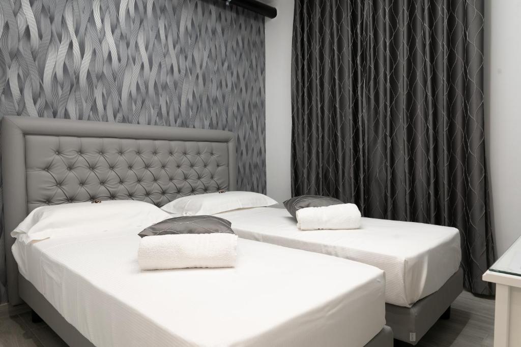 2 camas en una habitación con sábanas blancas en PRESTIGE casa vacanze en Catanzaro