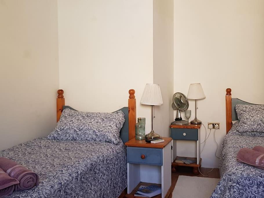 una camera con due letti e un tavolo con una lampada di Traditional Maltese House in Birgu 
