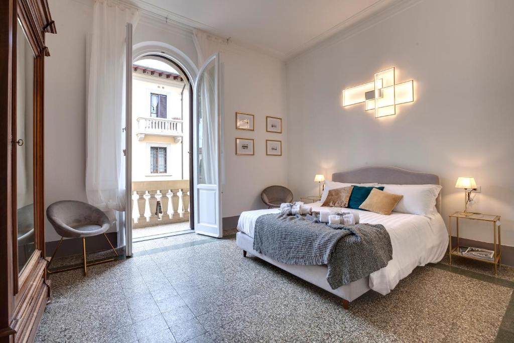 a bedroom with a bed and a large window at Mamo Florence - Magenta Apartment in Florence
