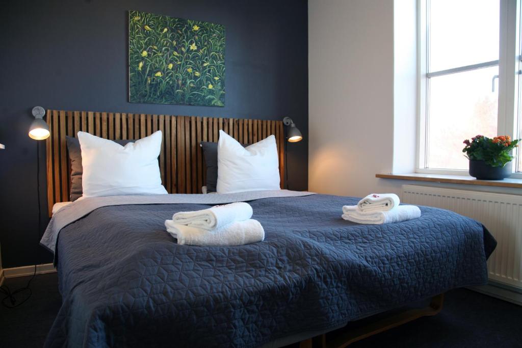 1 dormitorio con 1 cama con toallas en Nexø Modern Hostel. Private Rooms, en Neksø