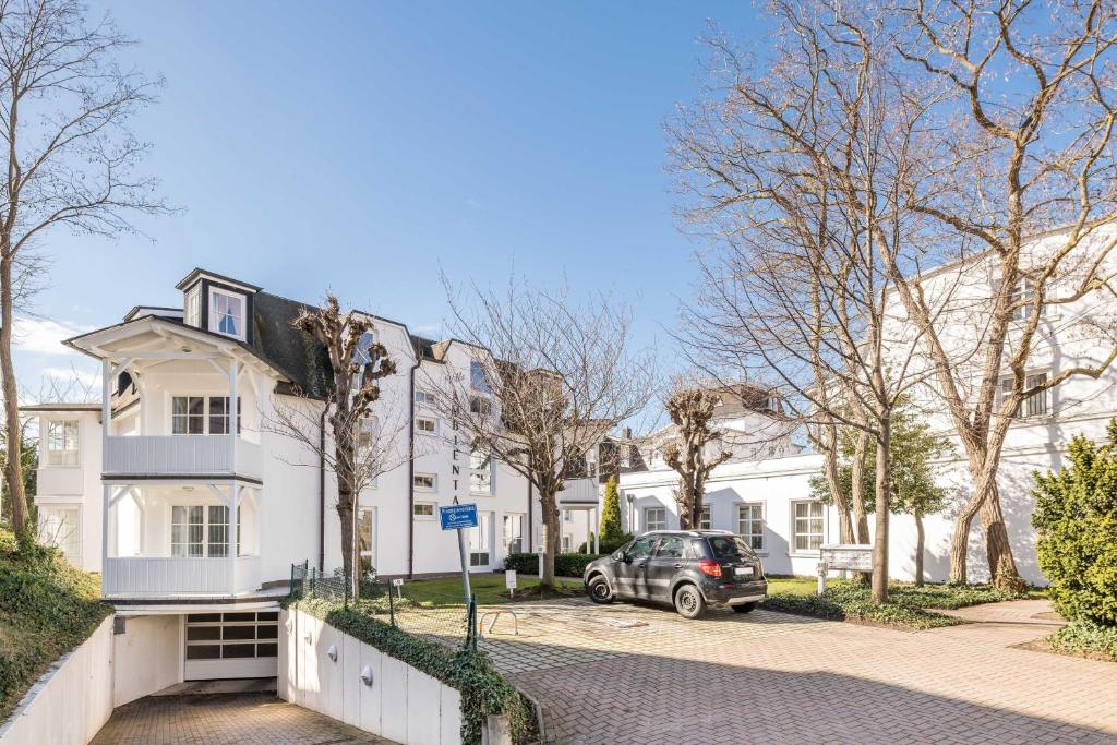 a white house with a car parked in front of it at Villa Ambienta in Binz